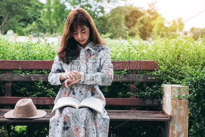 迷人的亚洲女人阅读和放松在公园