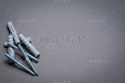 深灰色表面的塑料销子和螺钉