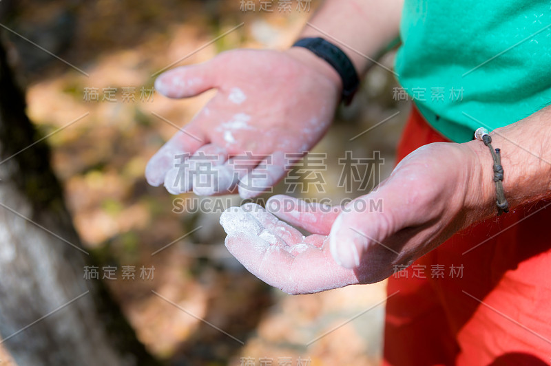 一个登山者的手在户外攀登练习前在森林的镁砂的特写。登山和运动的概念