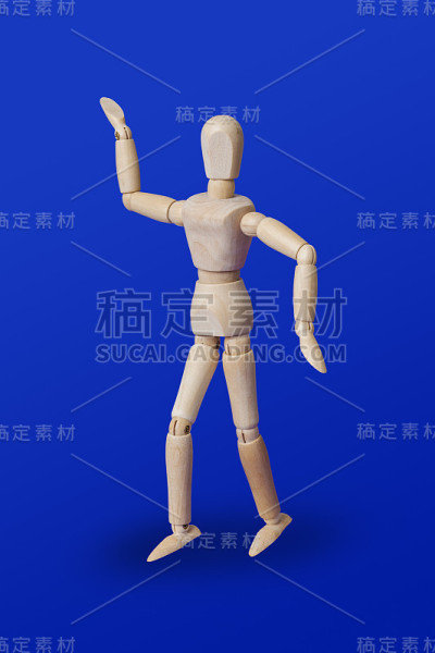 在蓝色上跳舞的木制玩具人物