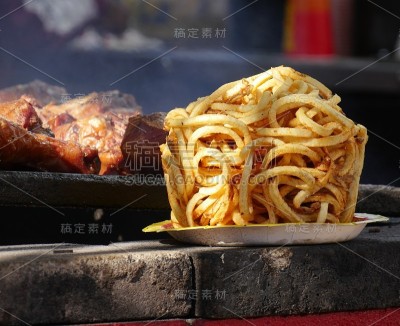 在美食节上，巨大的薯条和火鸡腿在烤架上烧烤