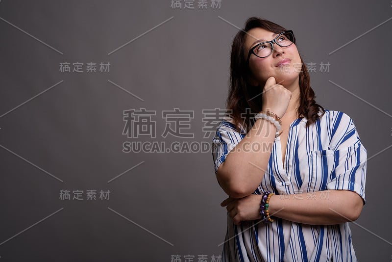 工作室拍摄的成熟美丽的亚洲女商人在灰色的背景