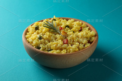 木碗和美味的米饭在绿松石背景，近距离