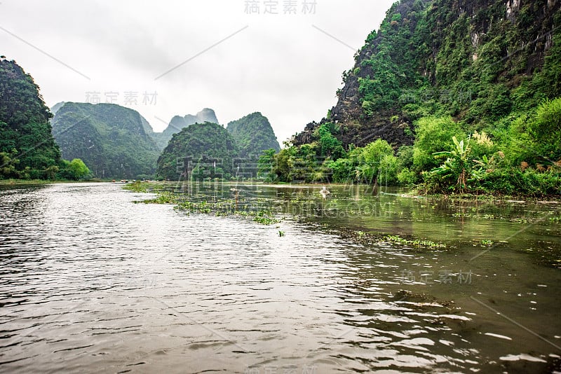 Tam Coc国家公园-游客在越南宁平省的吴洞河上乘船旅游，Trang An景观综合体-由喀斯特塔和