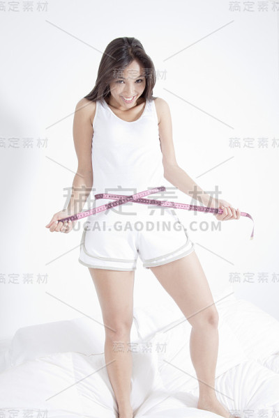 年轻女子用卷尺量腰围