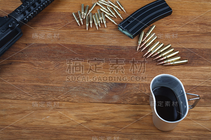 木桌上放着一把步枪和一杯咖啡