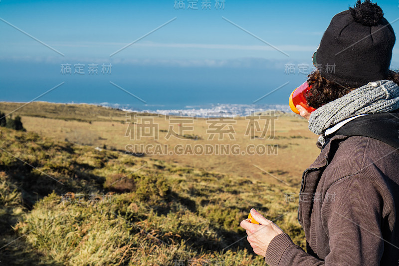 年轻人饮用水，从山上俯瞰大西洋海岸线，徒步旅行的概念，巴斯克国家，法国