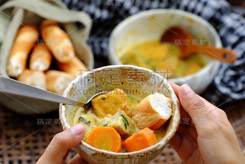 人们早餐吃美味的黄色素食咖喱碟碗和面包