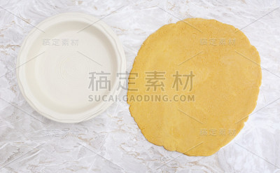 油酥皮擀成圆圈，以排在馅饼盘上