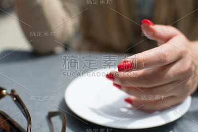 美丽的年轻女孩的手与红色抛光指甲