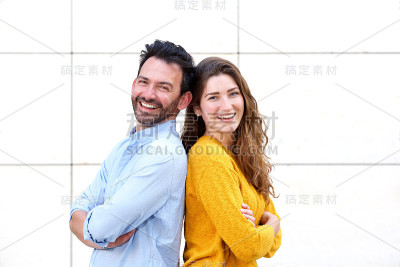 一对有趣的夫妇背靠背站着，双臂交叉