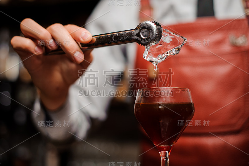 调酒师正在往鸡尾酒里加冰块