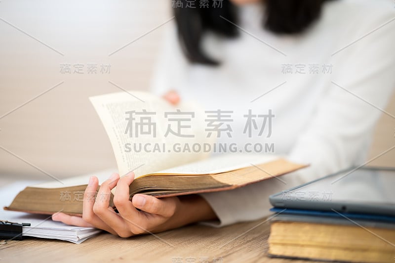 一位穿着白衬衫的亚洲女学生坐在大学里读书