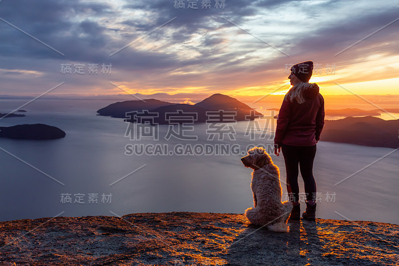 爱冒险的女孩带着狗在山顶徒步旅行