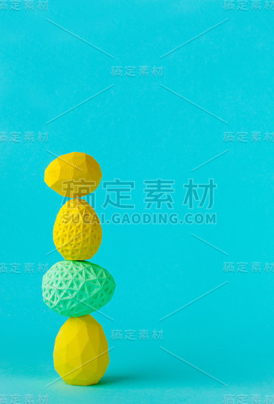 几何的复活节彩蛋在蓝色的背景上彼此站在一起
