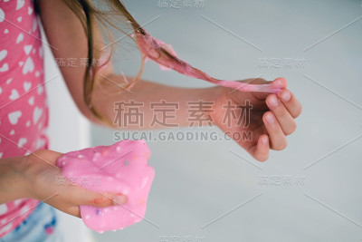 一个小女孩的头发被黏液弄脏了。孩子的头发被粉红色的黏液缠住了。
