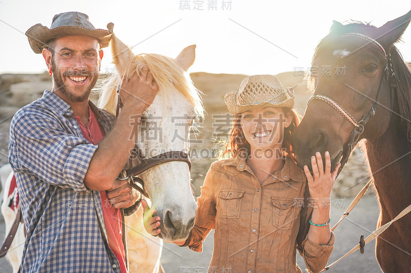 动物爱好者夫妇与无bitless马在阳光明媚的一天内牧场畜栏-快乐的人有乐趣的训练在他们的农场-爱和