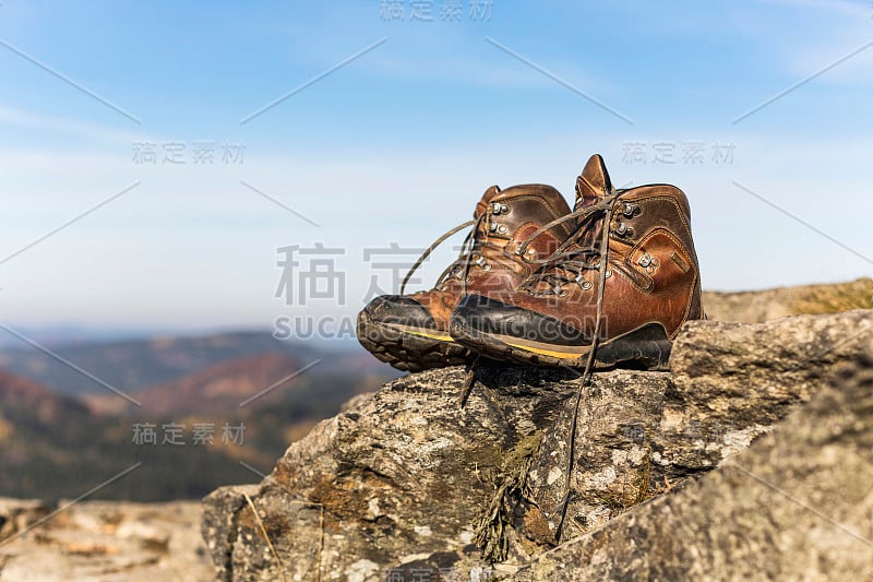 冬季运动风格的女子登山靴在岩石上。天然皮革和毛皮。重型耐寒外底