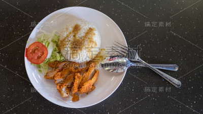 炸鸡蒸饭配酱汁、番茄片和卷心菜