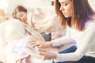 失望的女人看着电子温度计