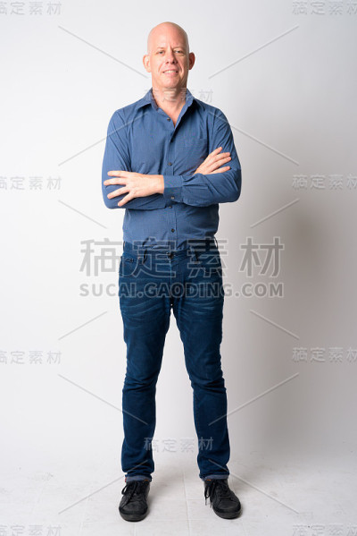 全身照片的快乐成熟的秃头商人微笑着双臂交叉