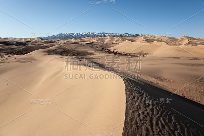 背景是戈壁沙漠，沙丘山