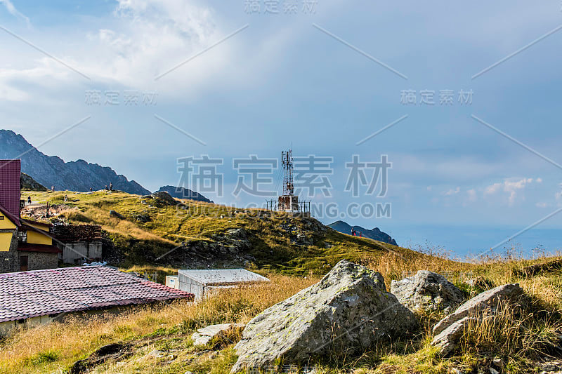 一个山岩石的特写镜头在一个山的风景与细胞塔在背景