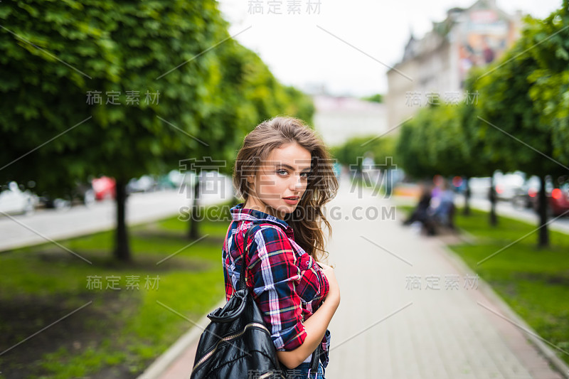 时尚写真，年轻时尚女子背双肩包在城市里煨