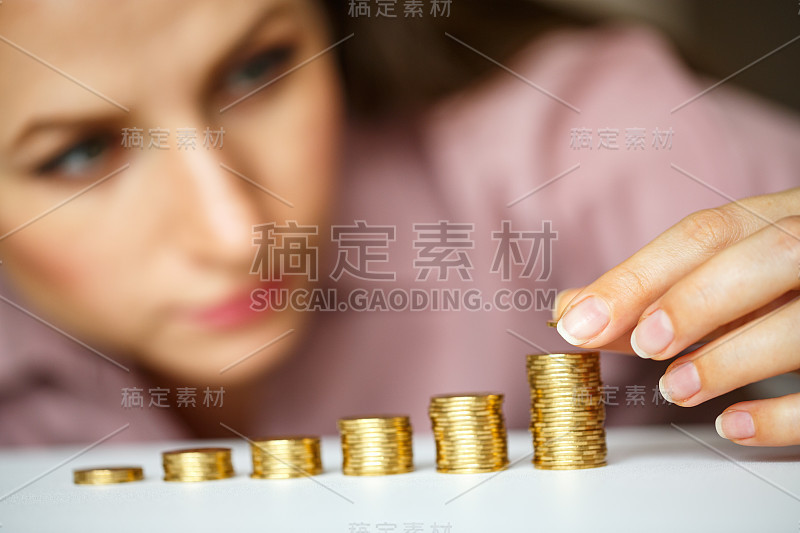 女人把金币堆成越来越大的柱子