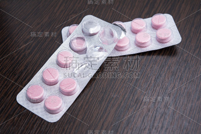 桌上有包装好的粉色药片