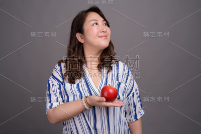 工作室拍摄的成熟美丽的亚洲女商人在灰色的背景