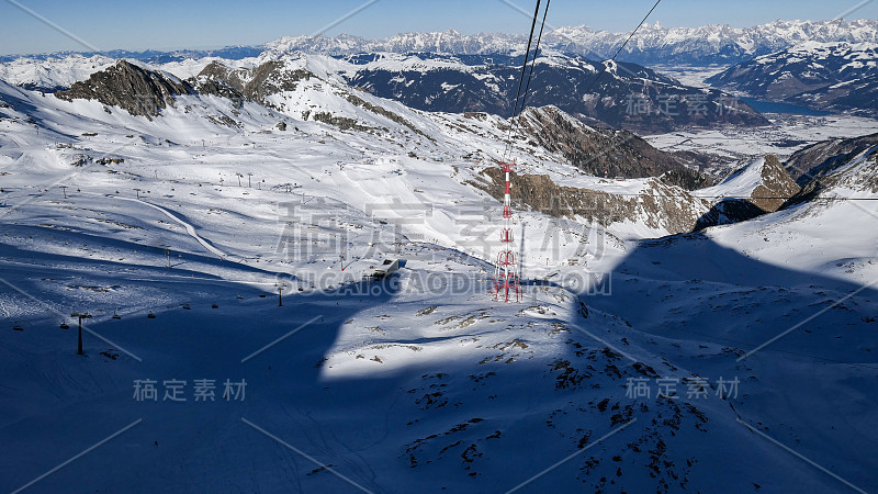 空中阳光下的奥地利阿尔卑斯山冬季滑雪斜坡的大阴影