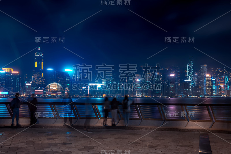 香港城市夜景。在海滨散步的游客