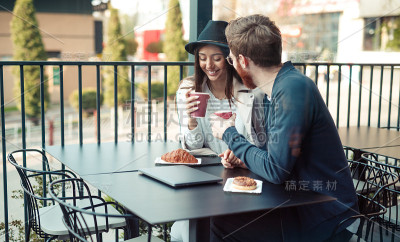 一对年轻夫妇在街边的餐馆里聊天