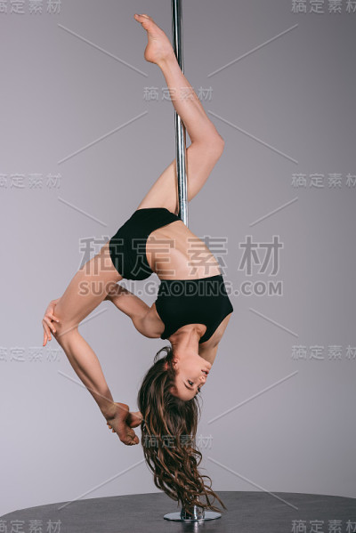 美丽灵活的钢管舞者与塔练习