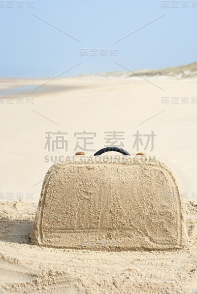 沙滩上用沙子做的手提箱