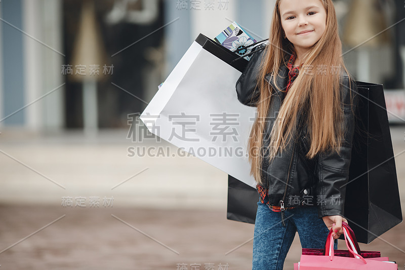 有型的小女孩拿着一堆袋子去超市购物