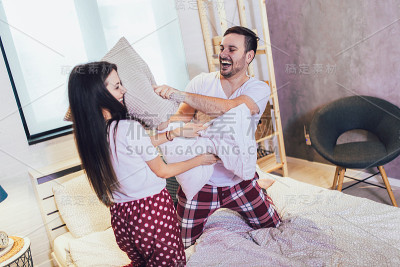 一对夫妇在玩枕头大战