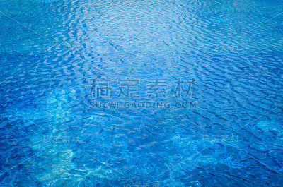 照片中的水在游泳池与阳光反射
