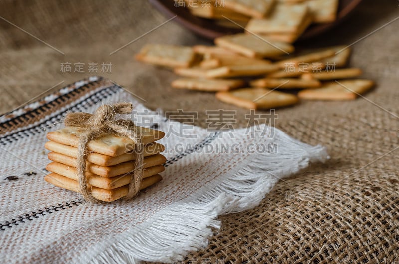 亚麻毛巾上放着一堆咸饼干。