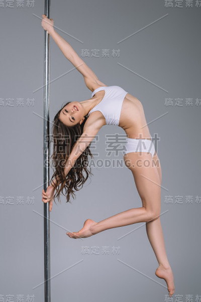 女孩穿着运动服，拿着杆子锻炼，看着镜头