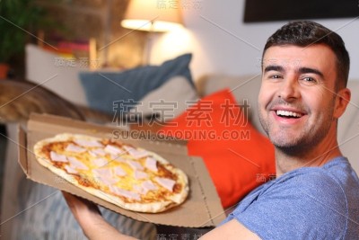 兴高采烈的年轻人拿着一个披萨
