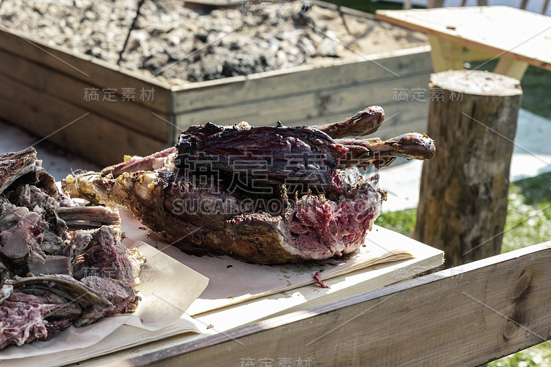 野猪肉烤熟，烧烤木桌切肉露营