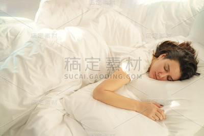 一个年轻美丽的女人独自睡在卧室的床上
