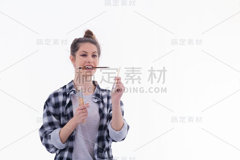 专注的女艺术家用牙齿拿着铅笔