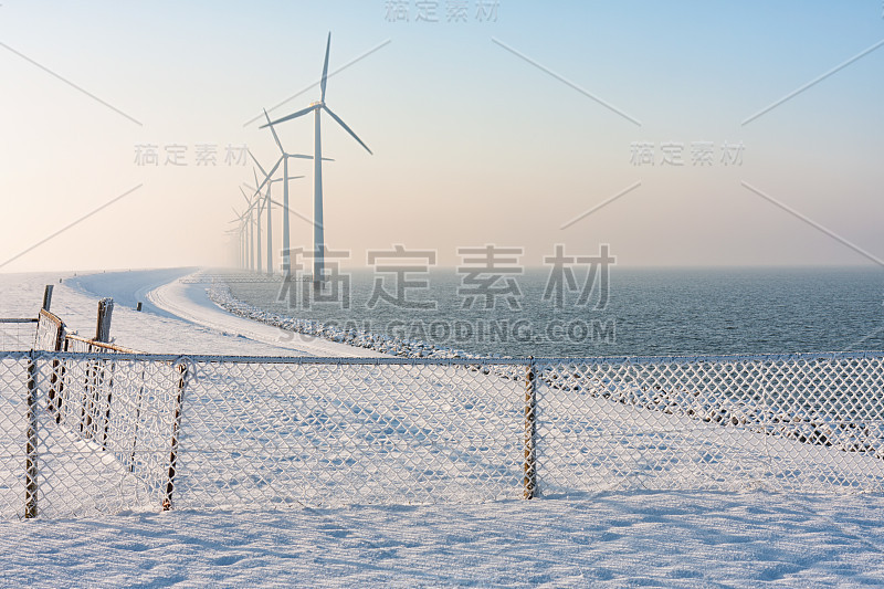 荷兰堤防冬天有雪，围栏和风力发电机