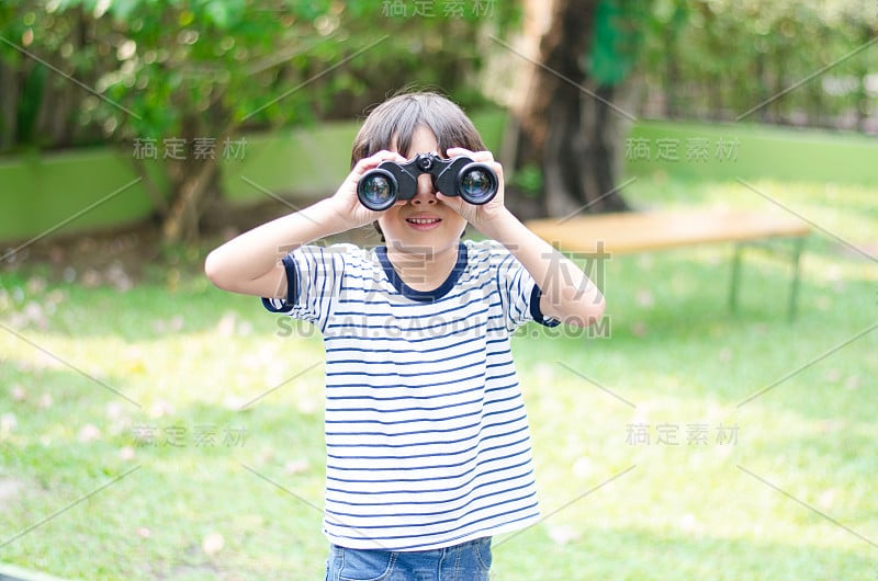 小男孩用双筒望远镜看