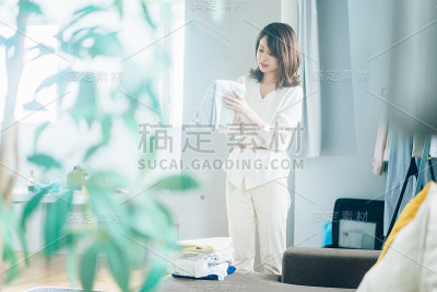 一个年轻女子在家里叠衣服