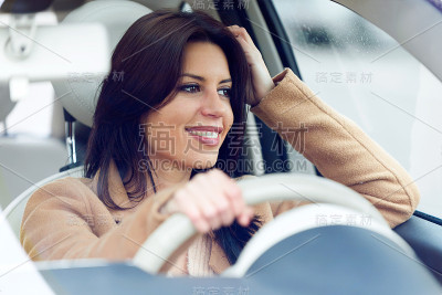 漂亮的年轻女人开着她的车。
