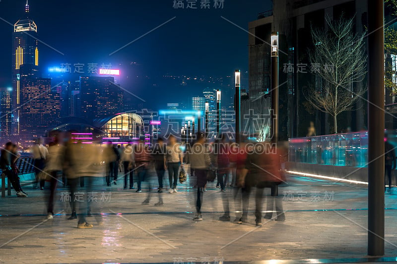 香港城市夜景。在海滨散步的游客